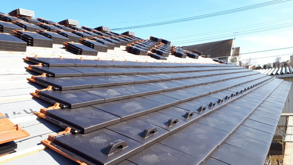 「洋瓦を使用した屋根工事の現場。平瓦の施工風景が分かる建築・リフォーム写真」