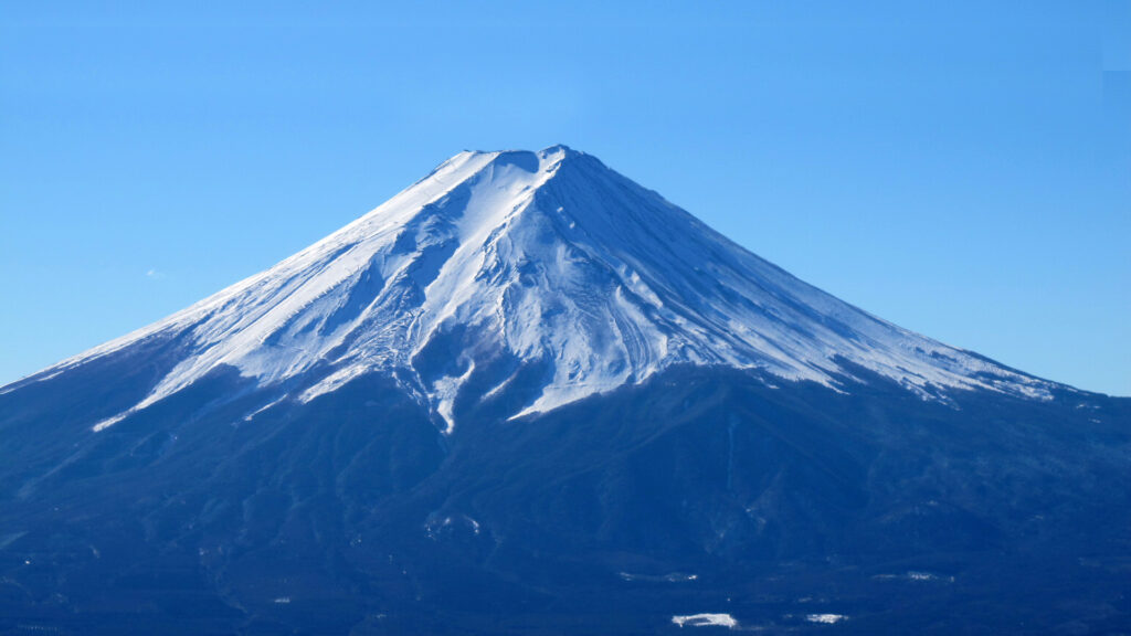 「三ツ峠から見た富士山の風景。残雪の山頂と青空が広がる自然写真」